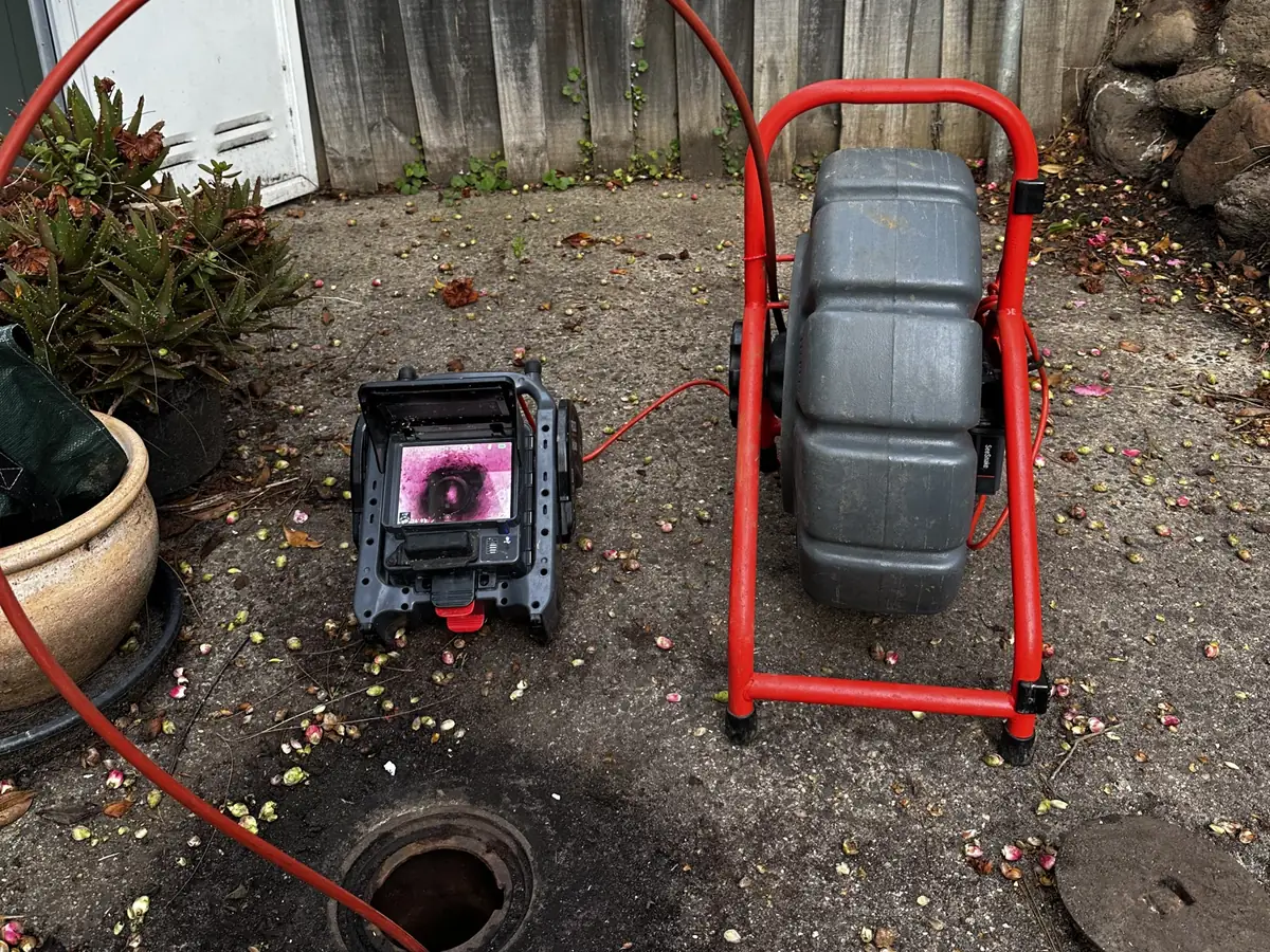 Bay Plumbing drain camera reel and monitor set up at a yard drain on a job.